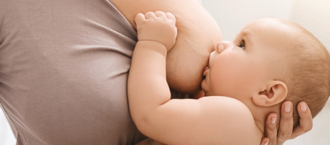 Mutter umarmt und stillt Baby in richtiger Stillposition
